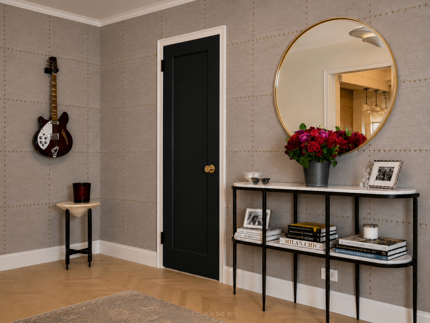 Rock star foyer with studded wallpaper, electric guitar, round mirror, and red roses