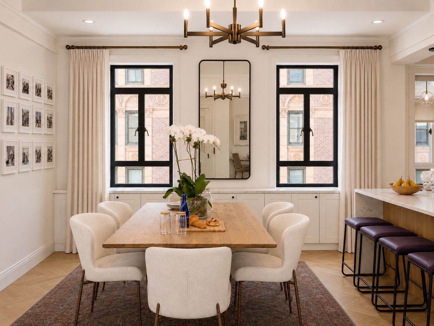 Dining room with wood table, brass chandelier, and gallery wall